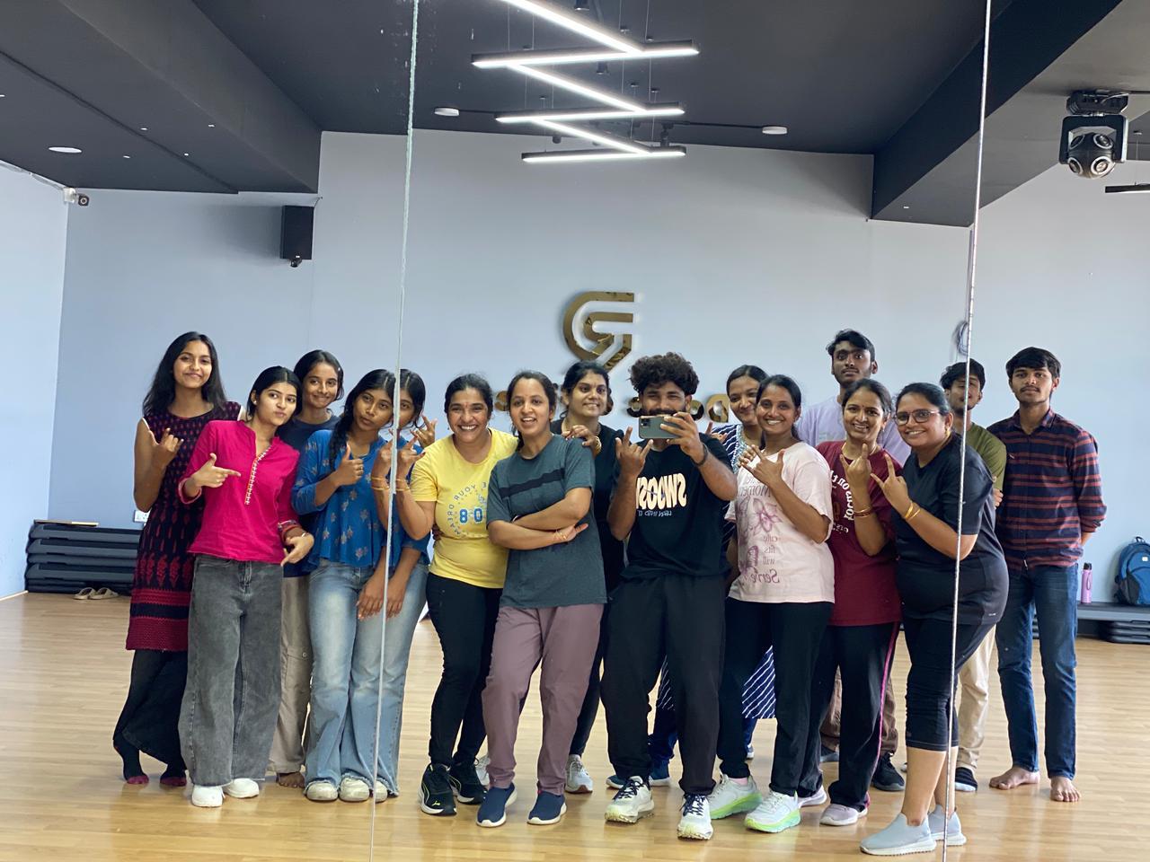 A group of students smiling and posing after a dance class