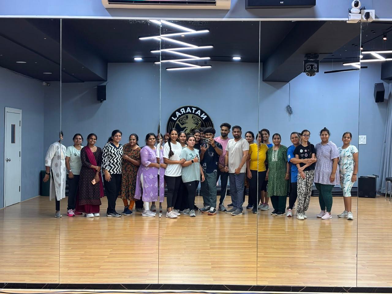 Students and instructors posing in front of the studio mirror