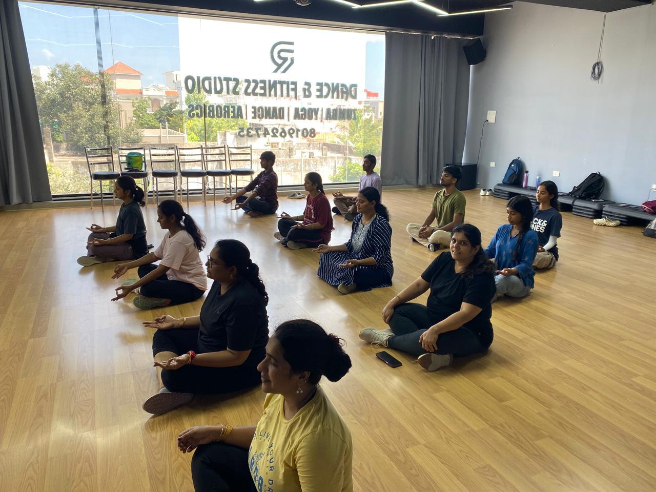 Students meditating cross-legged during a yoga class